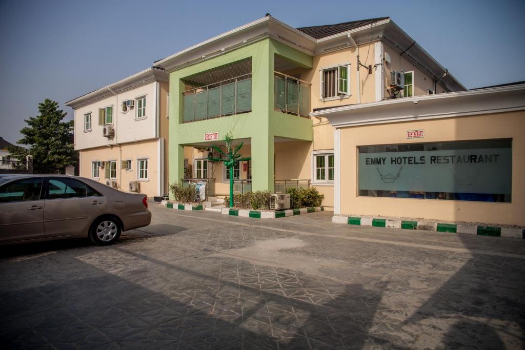 a car parked in a parking lot in front of a building at Emmy Hotels & Suites in Lekki