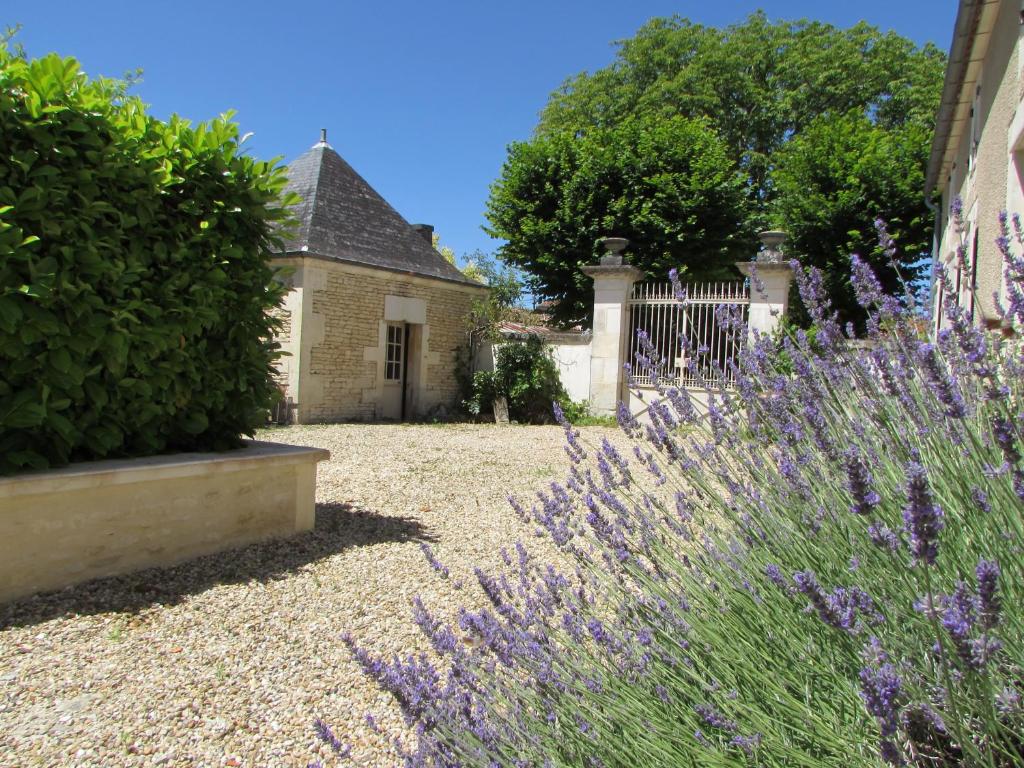 a garden with purple flowers in front of a house at Chambres des Lunes in Aumagne