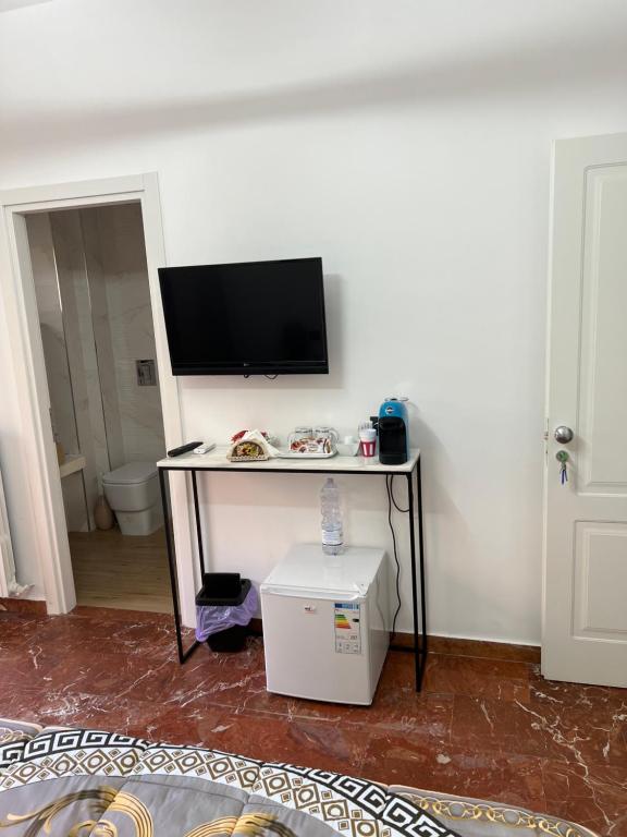 a room with a table with a television on a wall at Rooms lungomare in Crotone