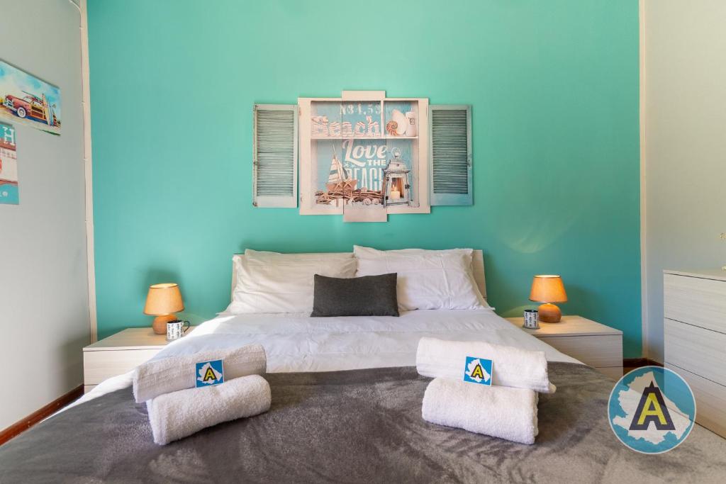 1 dormitorio con 1 cama grande y pared azul en Casa Del Bello - Appartamento di fronte al mare a Silvi en Silvi Marina