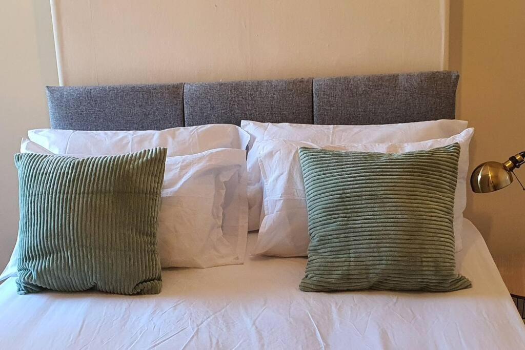 a bed with two pillows and two green and white pillows at The Fenton Lodge in Fenton