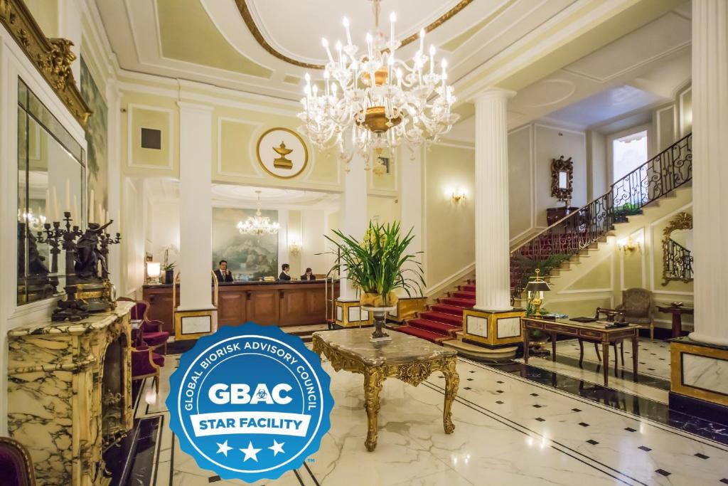 a lobby with a chandelier and a sign that says gaba star facility at Grand Hotel Majestic gia' Baglioni in Bologna