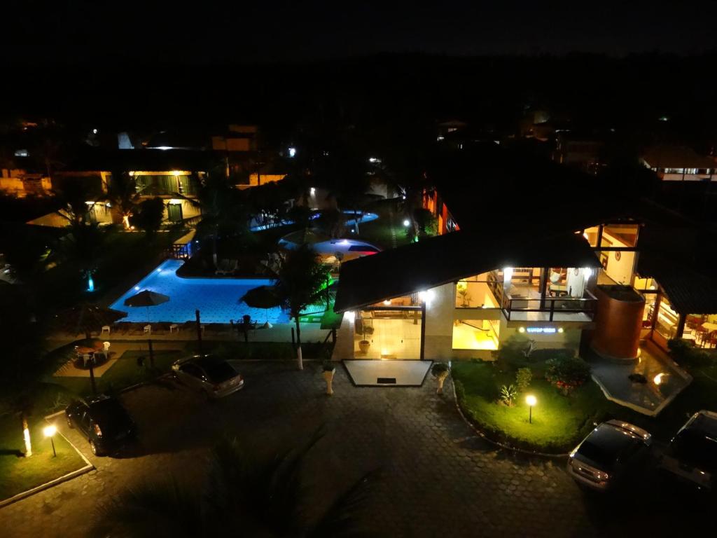 - une vue sur la piscine la nuit dans l'établissement Porto Bali Hotel, à Santa Cruz Cabrália