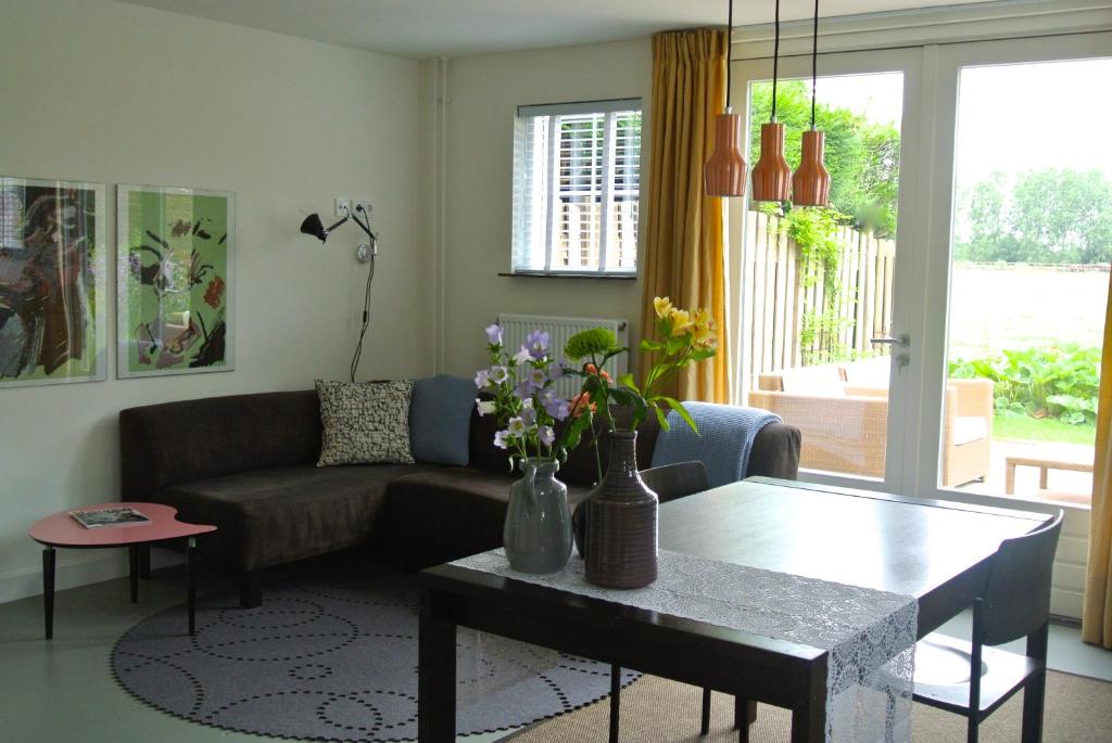 De Heerlykheid في نوينين: غرفة معيشة مع أريكة وطاولة