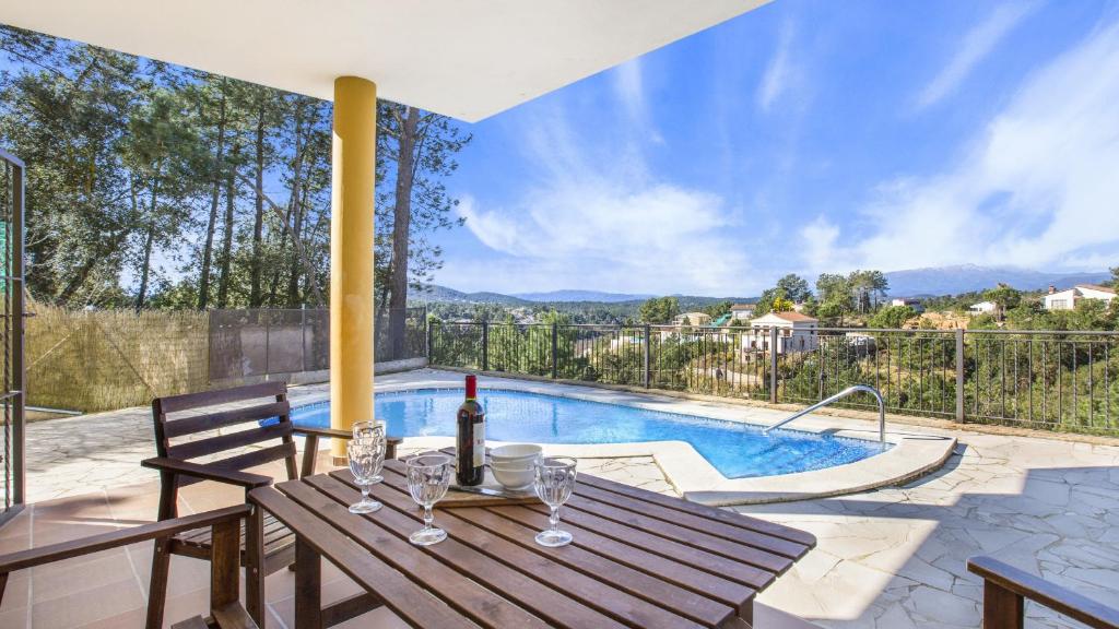une terrasse avec une table et une piscine dans l'établissement Villa Camel - Lloret de Mar, à Mont Barbat