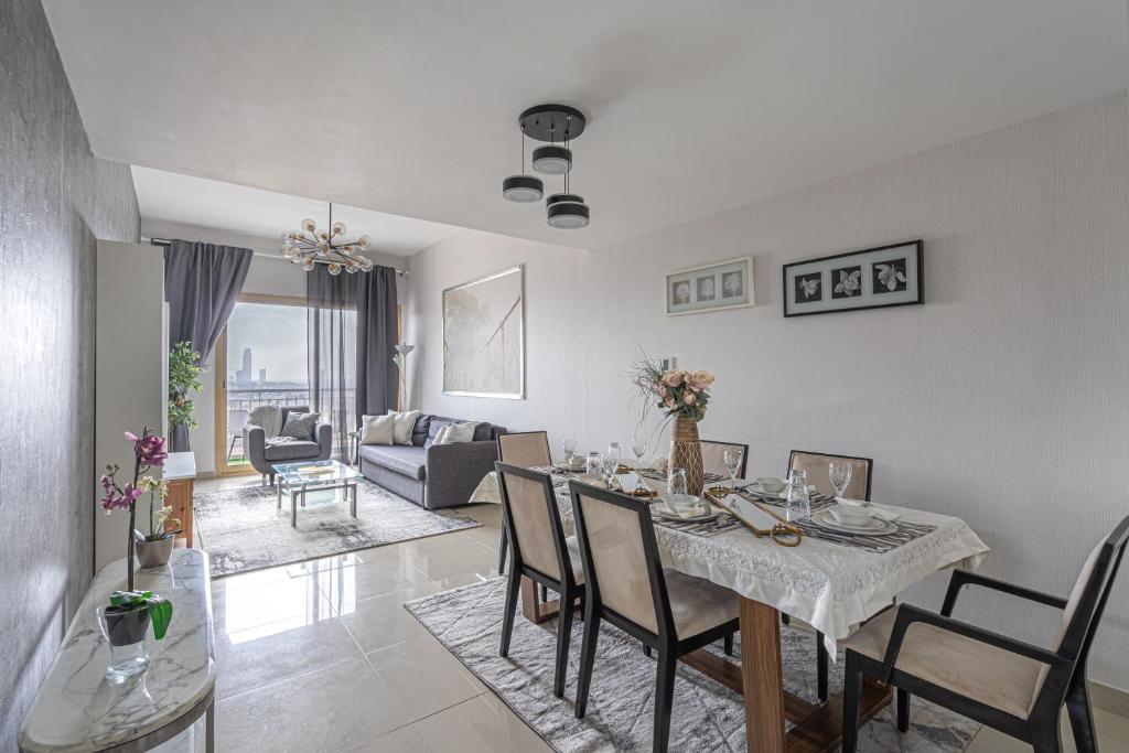 uma sala de jantar e sala de estar com mesa e cadeiras em HiGuests - Luxurious 1BR Apartment with balcony in JVC em Dubai