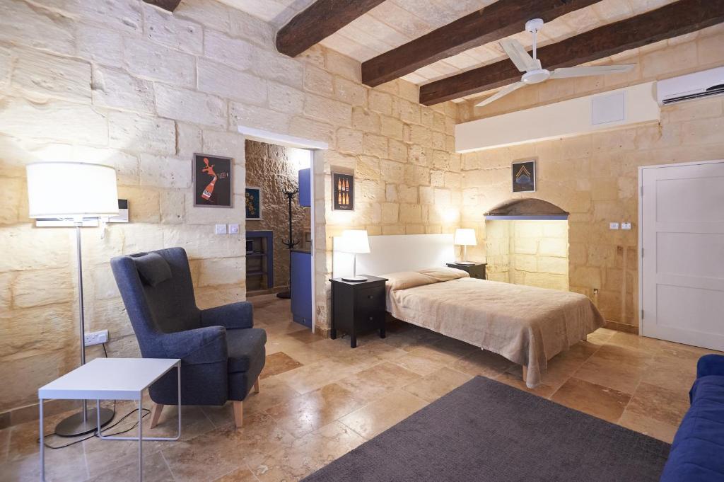 1 dormitorio con 1 cama, 1 sofá y 1 silla en Casa San Carlo, en La Valeta