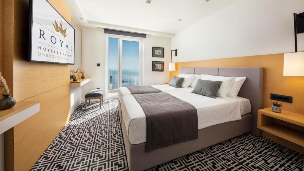 a hotel room with a large bed and a television at Royal Neptun Hotel in Dubrovnik