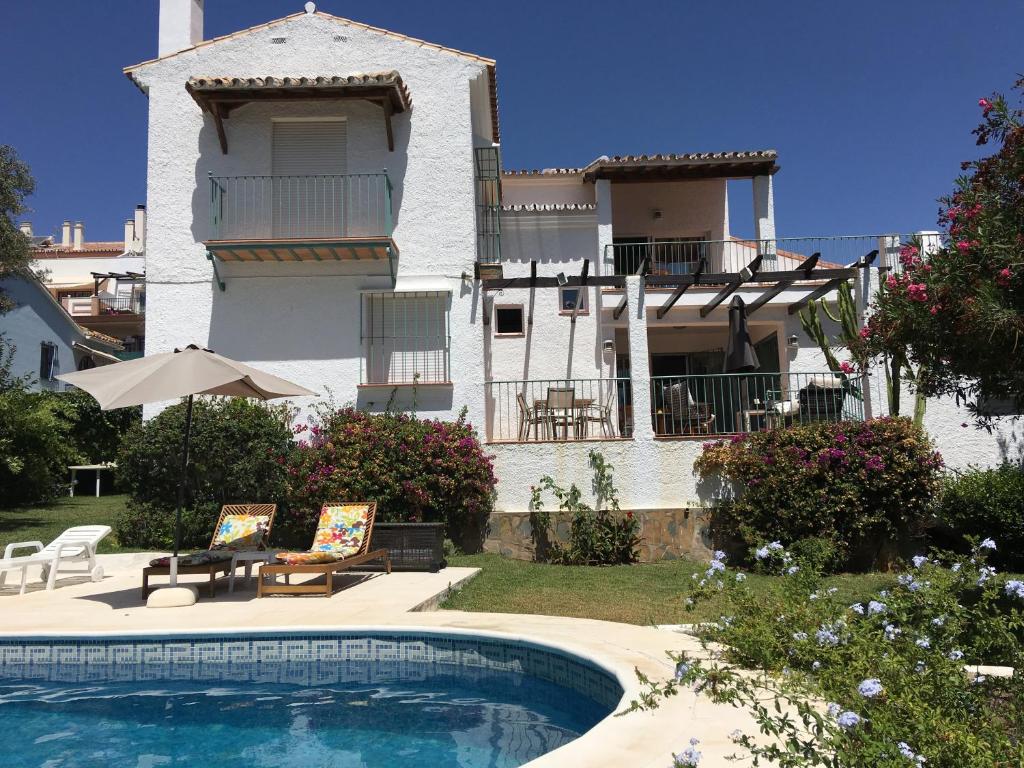 uma casa com piscina em frente a um edifício em Villa Mimosa em Marbella