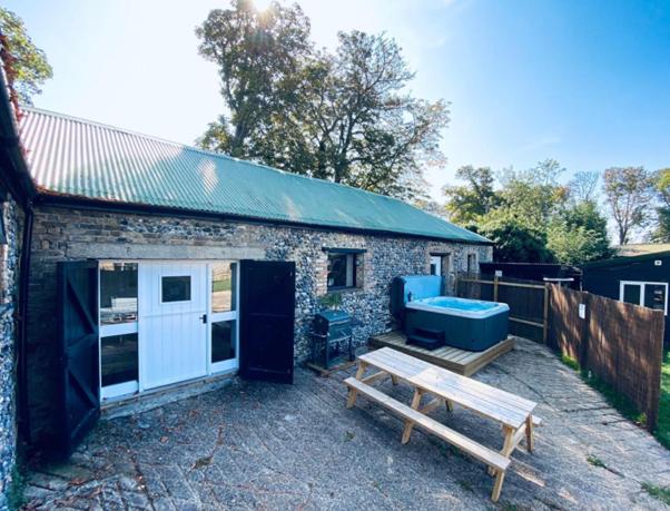 a backyard with a picnic table and a building at 5 Bed Barn Conversion - with private hot tub in Birchington