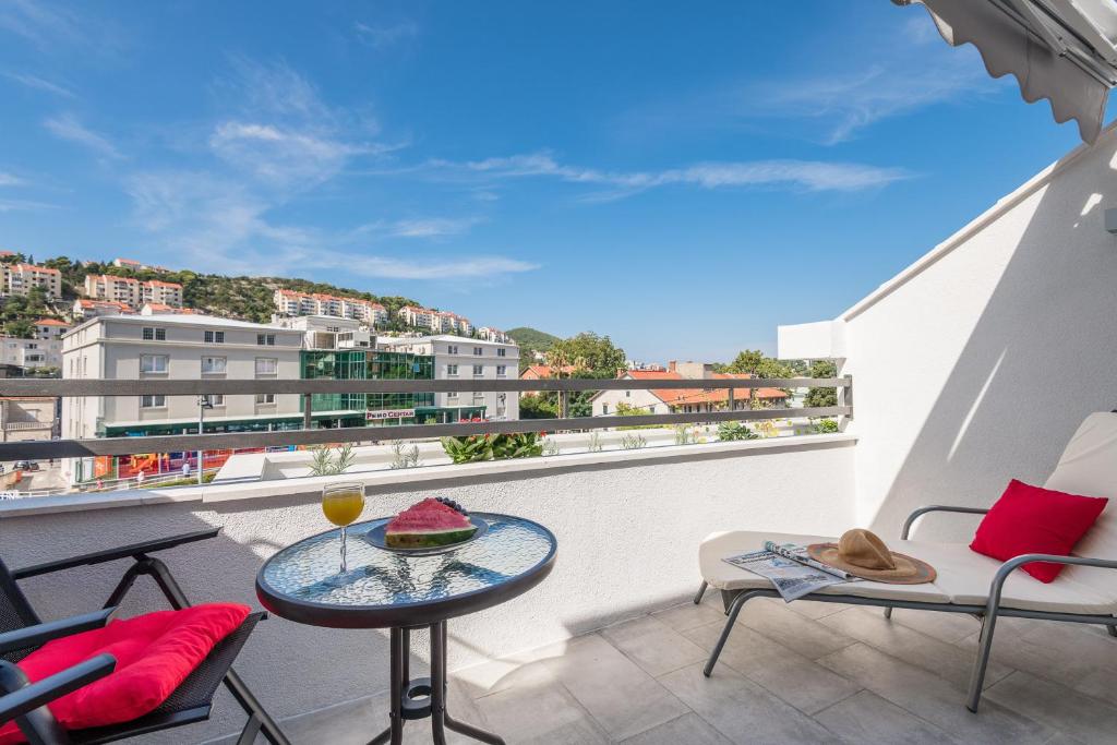 a balcony with a table and chairs and a view at Apartments Marando in Dubrovnik