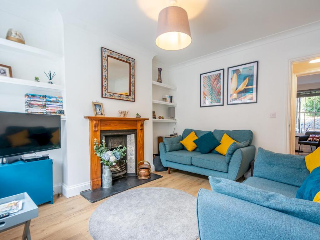 a living room with blue couches and a fireplace at Pass the Keys Cosy terrace within city walls ideal for exploring in Canterbury