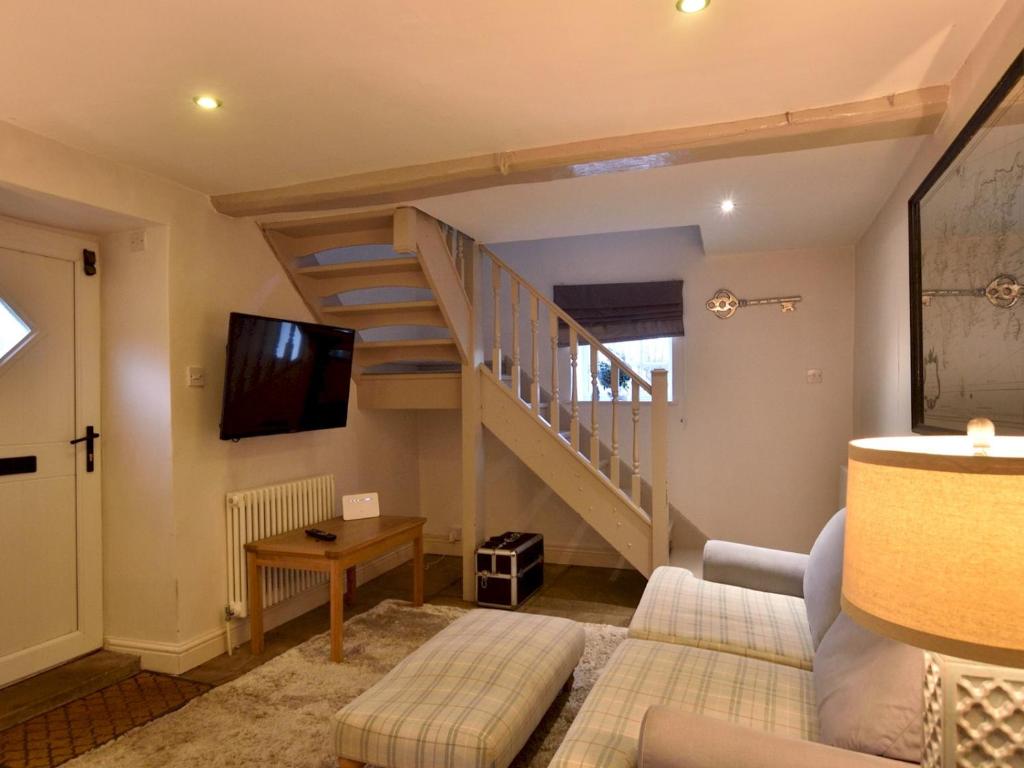 a living room with a staircase and a tv at Pass the Keys Scampton Cottage in Lincoln