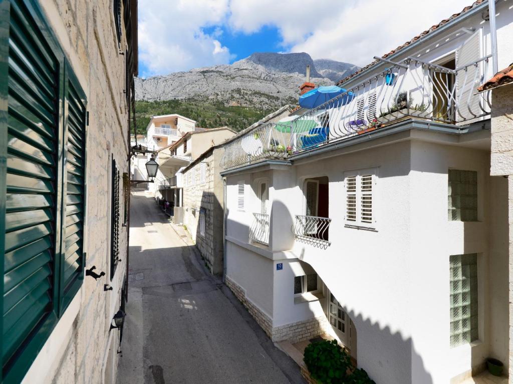 an alley with white buildings and a mountain in the background at Holiday Home Stara Lipa in Baška Voda
