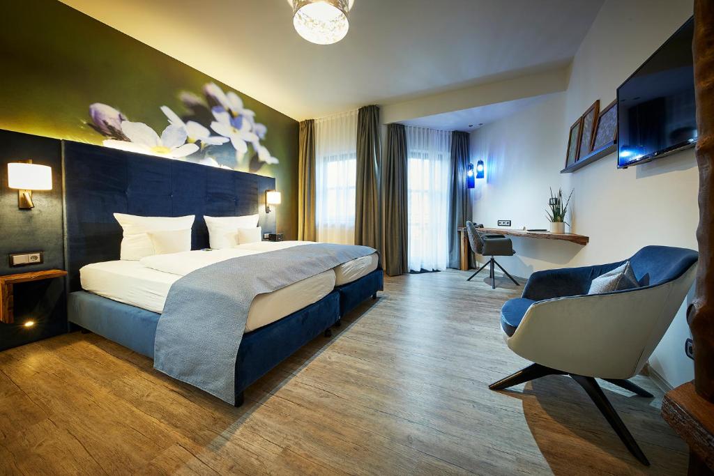 een hotelkamer met een bed en een stoel bij Landhotel Müller in Medebach