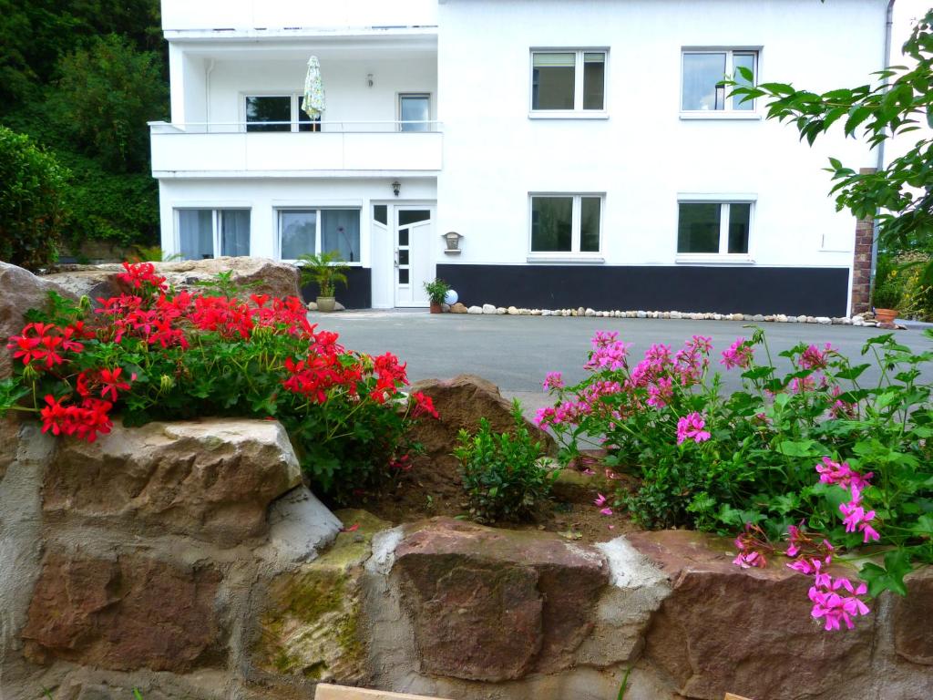 una pared de retención con flores frente a un edificio en Villa Luise, en Hameln