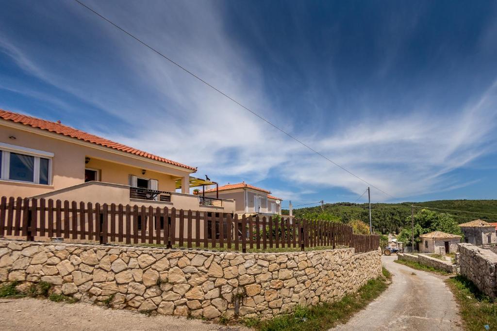a house with a stone wall next to a road at Dimitras House in Ágios Nikólaos