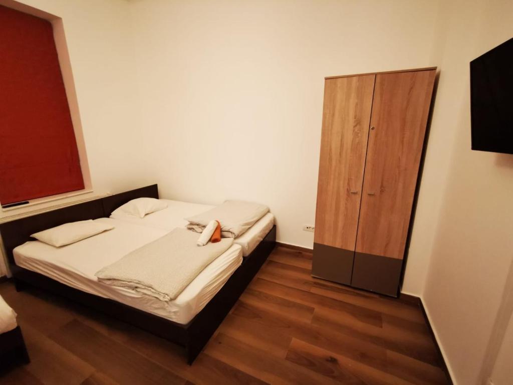 Central Accommodation PIATA ROMANA في بوخارست: غرفة نوم بسرير وخزانة خشبية