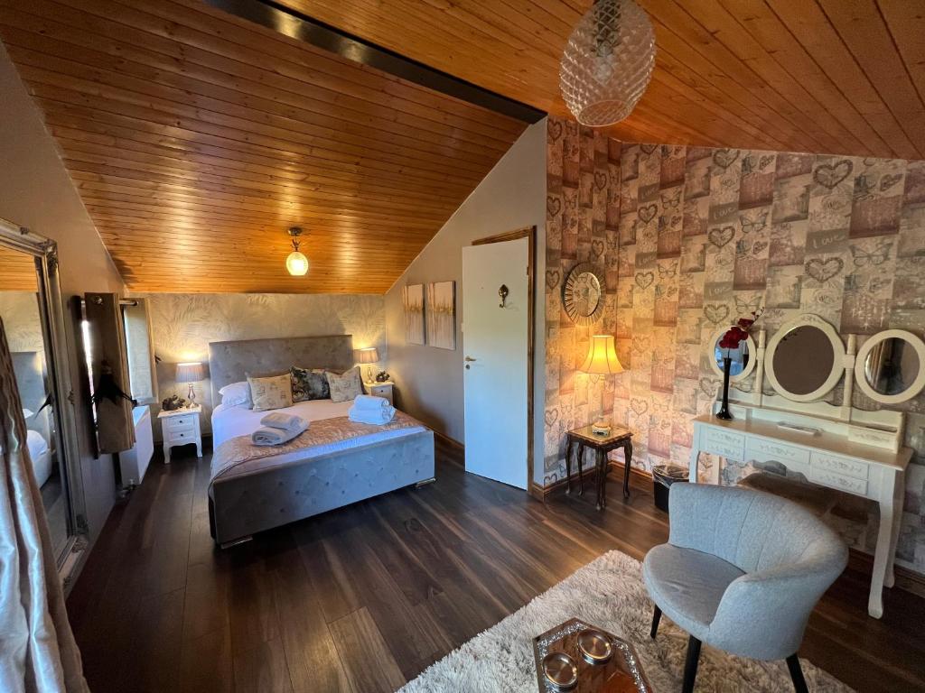 a bedroom with a bed and a chair in a room at Squirrel Lodge at Owlet Hideaway - with Hot Tub, Near York in York