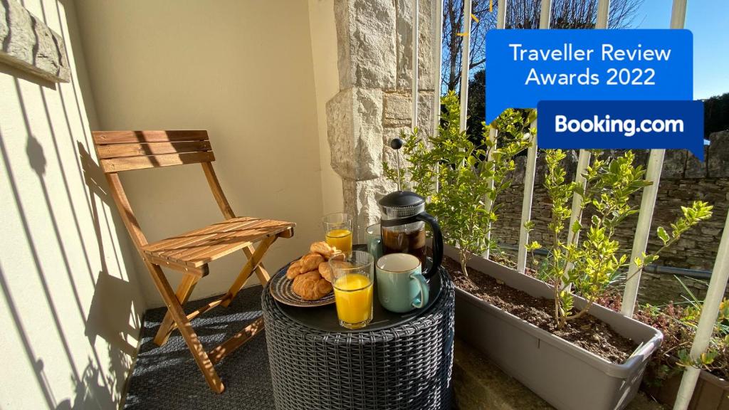 a table with two glasses of orange juice and a basket of bread at Spacious luxury flat in Swanage, close to beach in Swanage