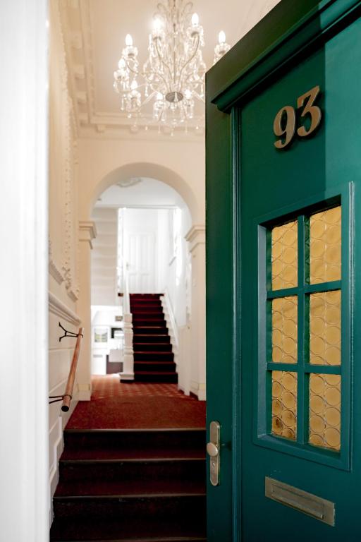 a hallway with a green door and stairs at Boutique Hotel Villa Oberkassel in Düsseldorf