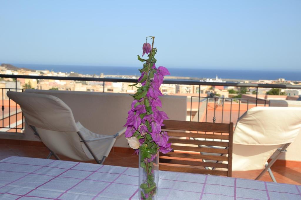 un jarrón lleno de flores púrpuras sentado en una mesa en Appartamento Yucca en Pantelleria