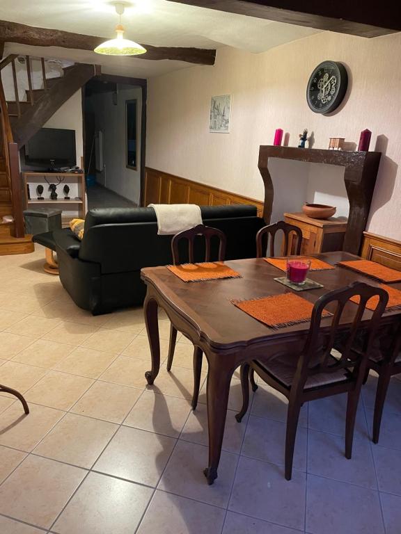 a living room with a table and a couch at A la petite maison de village in Sabarat