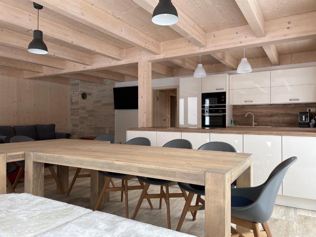 kuchnia i jadalnia z drewnianym stołem i krzesłami w obiekcie Chalet Rokytnice w Rokitnicach nad Izerą