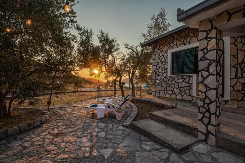 a bench sitting outside of a house with the sunset at Casa Nina in Neum