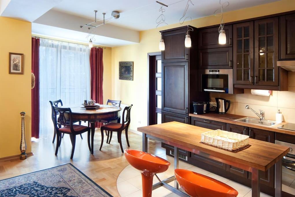 cocina y comedor con mesa y sillas en Trinity Apartment, en Cracovia