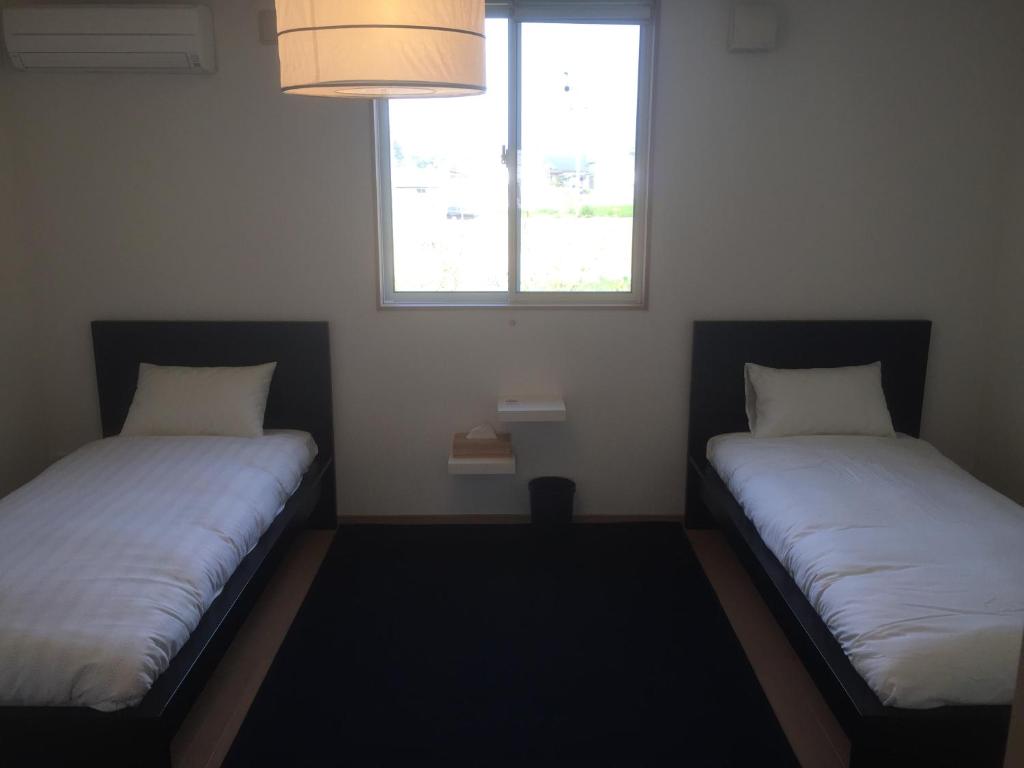 2 camas en una habitación pequeña con ventana en Nasu Townhouse N-3, en Nasushiobara