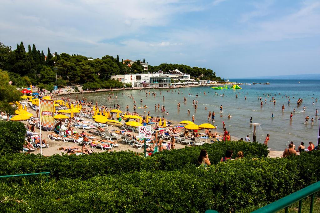 a crowd of people on a beach with umbrellas at Apartments Beautiful Sandy Beach in Split