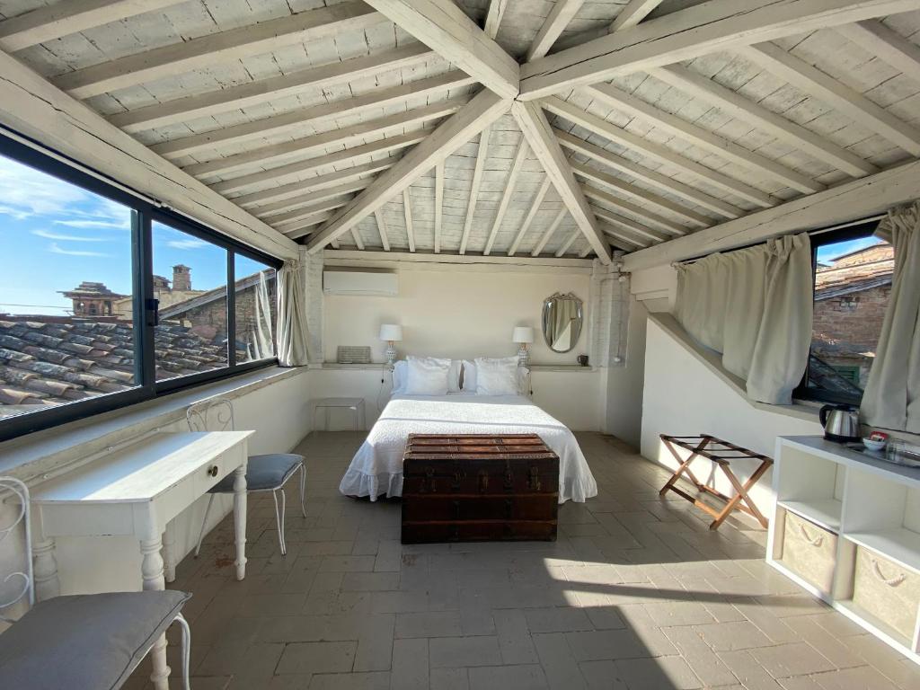 a bedroom with a bed in a room with windows at 1550 Residenza d’Epoca in Siena