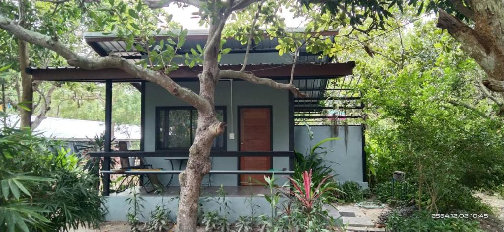 une petite maison verte avec un arbre en face dans l'établissement Farm Madame Fleur, à Cha Am