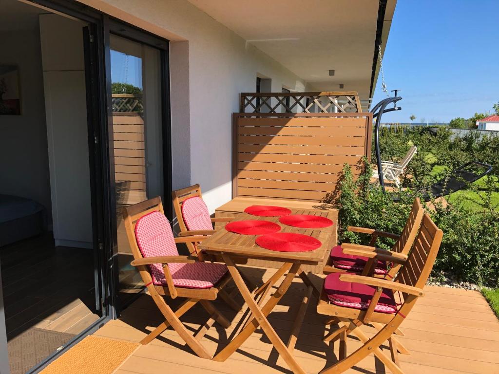 a wooden table and chairs on a deck at Apartament Julian Seaside Gardenia in Dziwnów