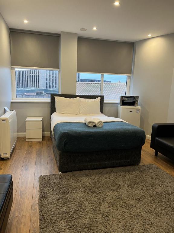 a bedroom with a bed and a large window at Showcase Apartments – Kimberley House in Leicester