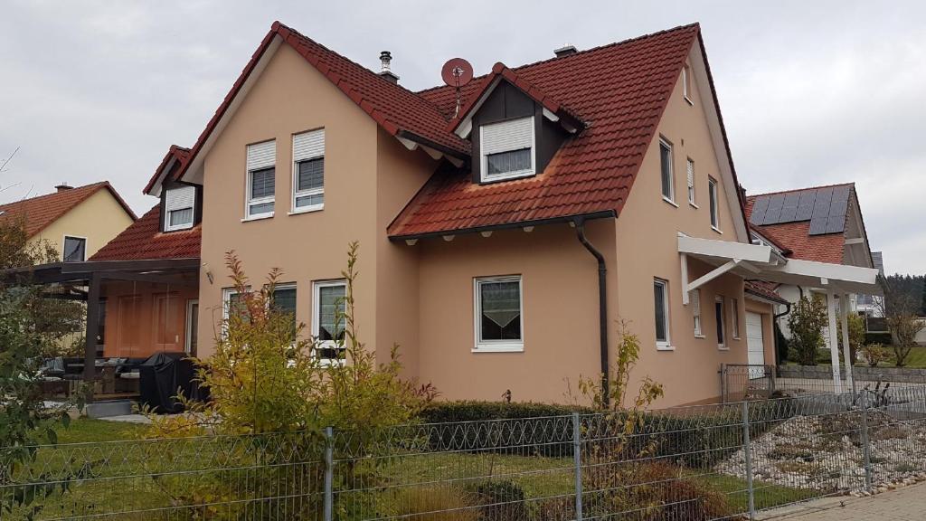 una casa con techo rojo en Ferienwohnung Am Kapellenäcker en Neumarkt in der Oberpfalz