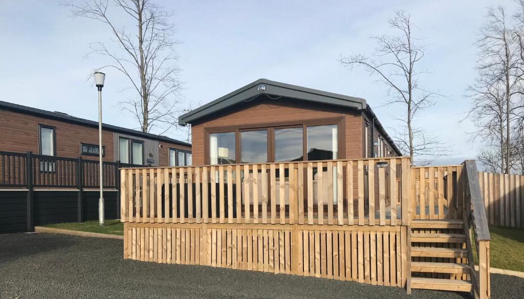 una pequeña casa con una valla de madera delante de ella en Number 47 @ Lilliardsedge, en Jedburgh