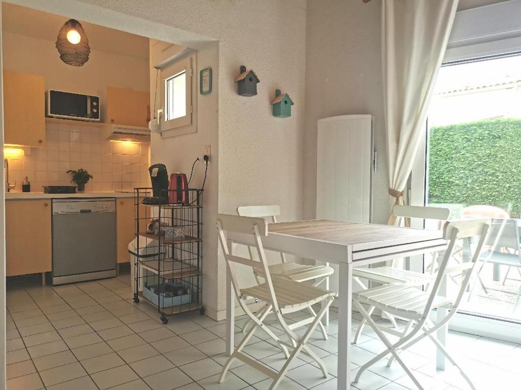 uma cozinha com mesa e cadeiras num quarto em Villa Santoline, Saint-Denis-d'Oléron em Saint-Denis-dʼOléron