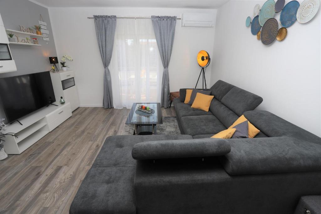 a living room with a couch and a television at Apartman Perla Deluxe in Poreč