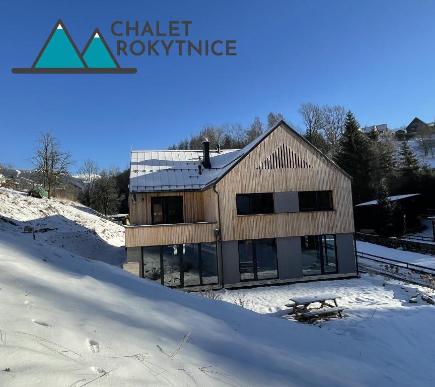 dom w śniegu ze słowami dach klimatycznych w obiekcie Chalet Rokytnice w Rokitnicach nad Izerą