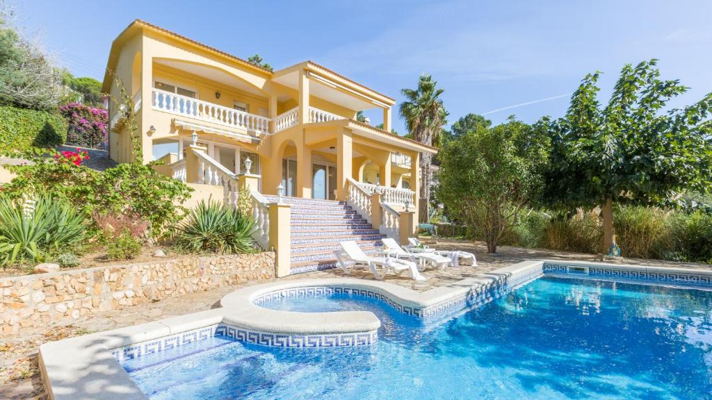 リョレート・デ・マルにあるVilla Cor - Lloret de Marの家の前にスイミングプールがある家