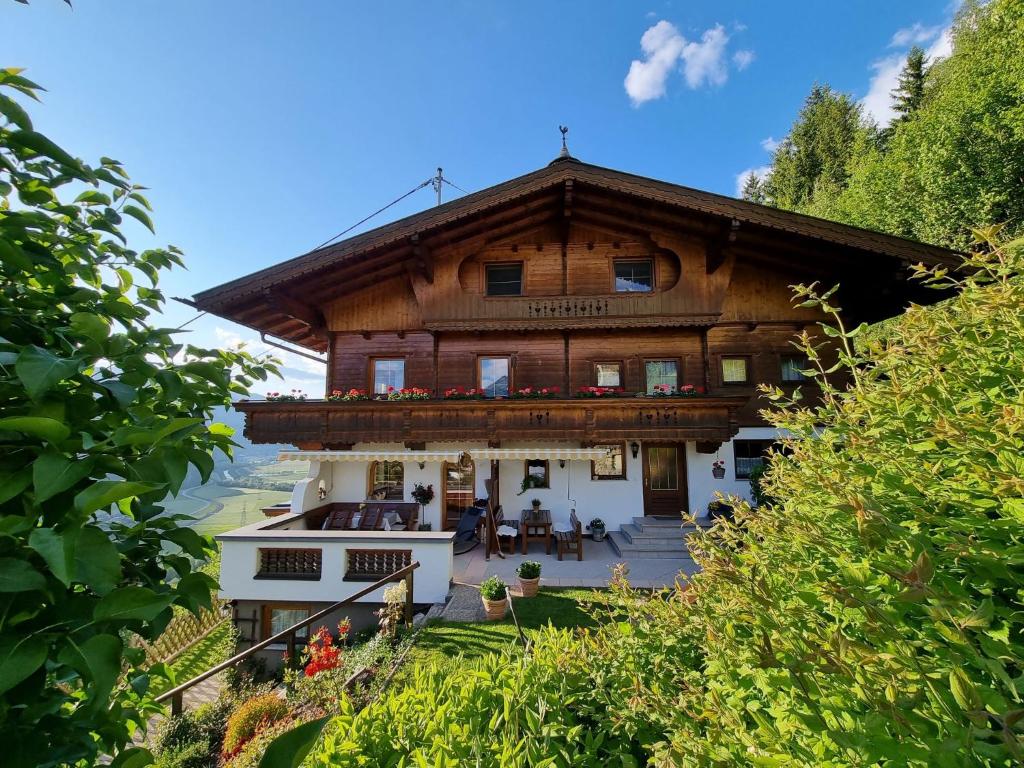 uma grande casa de madeira com um alpendre e pátio em Holiday Home Egger - ZAZ379 by Interhome em Aschau