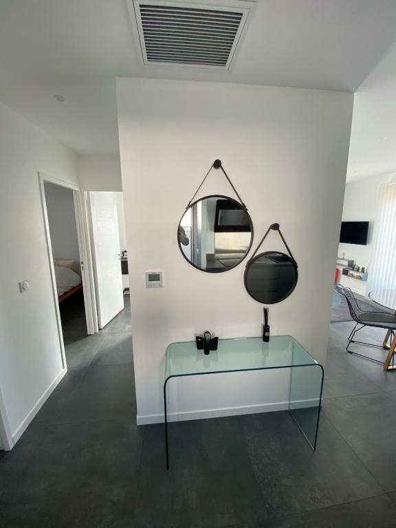 een kamer met een glazen tafel en een spiegel bij Logement Confort 2 Chambres / Séjour-cuisine proche de Montpellier in Saint-Aunès