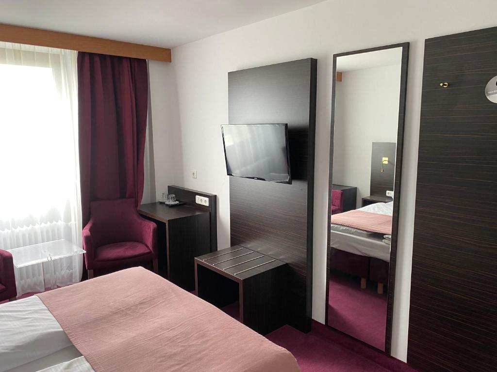 um quarto de hotel com uma cama e um espelho em Hotel Montree em Munique