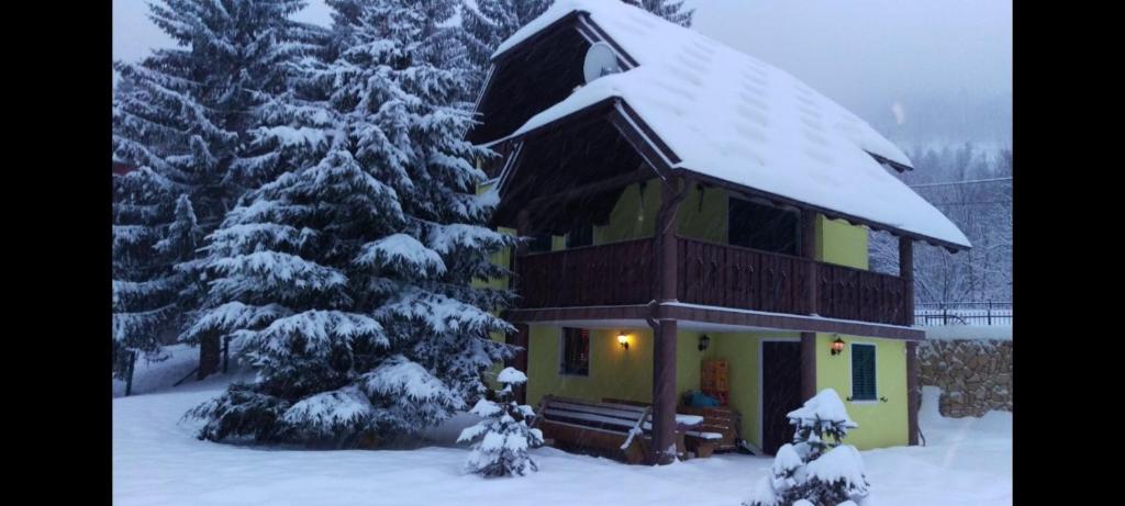 une maison avec un toit enneigé dans la neige dans l'établissement Kuća za odmor Gorski san, à Lokve