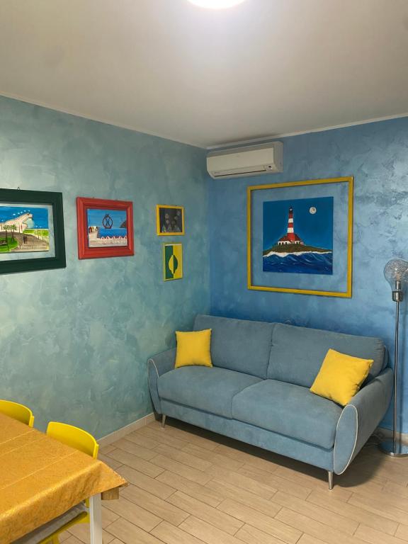 a living room with a blue couch and a table at E&C Suites Roma in Lido di Ostia