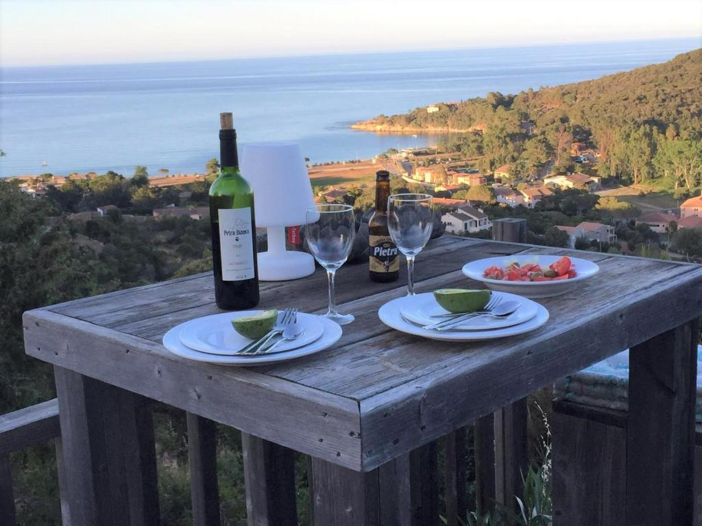 - une table en bois avec des verres à vin et des bouteilles de vin dans l'établissement VILLA GIOIA -Vue mer- proche plage de Favone, à Conca