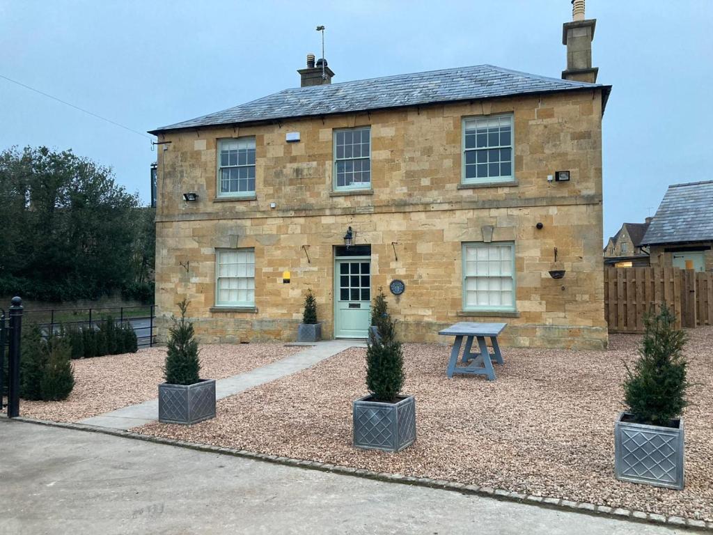 une maison en pierre avec une table de pique-nique devant elle dans l'établissement The Seagrave Arms, à Weston Subedge