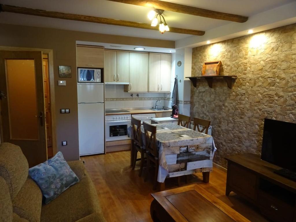 uma sala de estar com uma mesa e uma cozinha em Vista Collarada em Villanúa